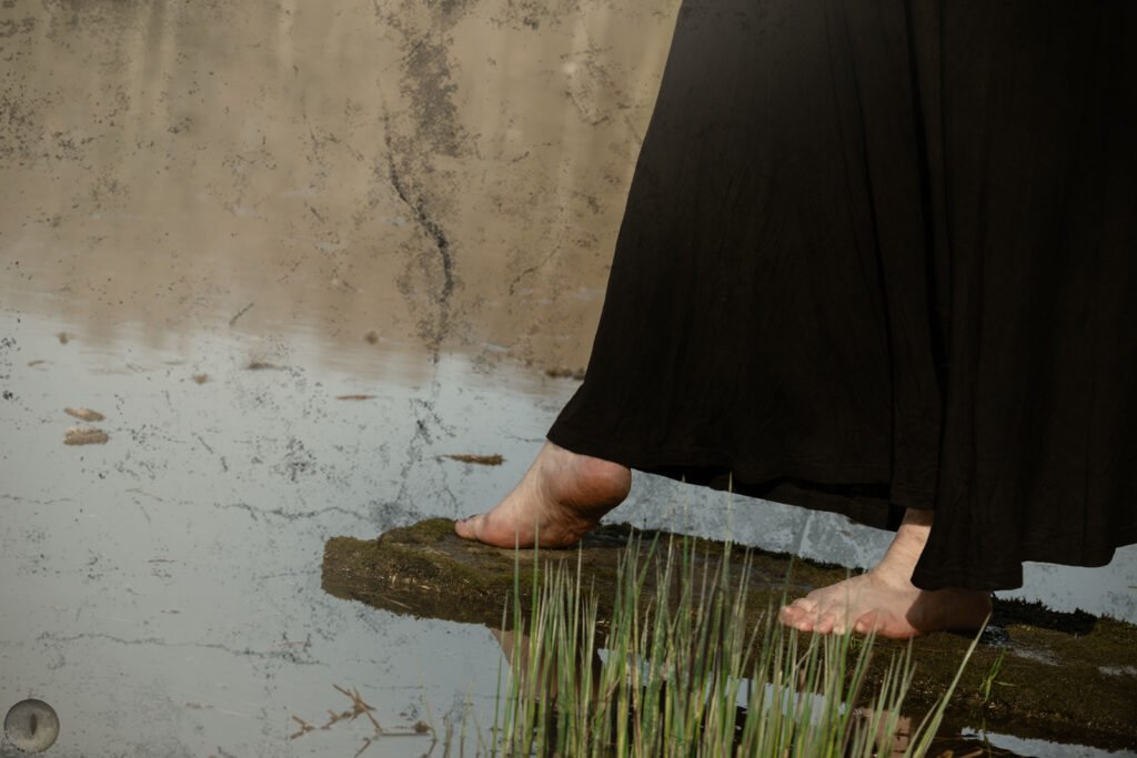 des pieds nus sur le rebord d'un étang, qui tentent d'aller marcher sur l'eau